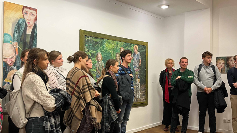 Študenti in študentke slovenistike občudujejo slike Jurija Kalana